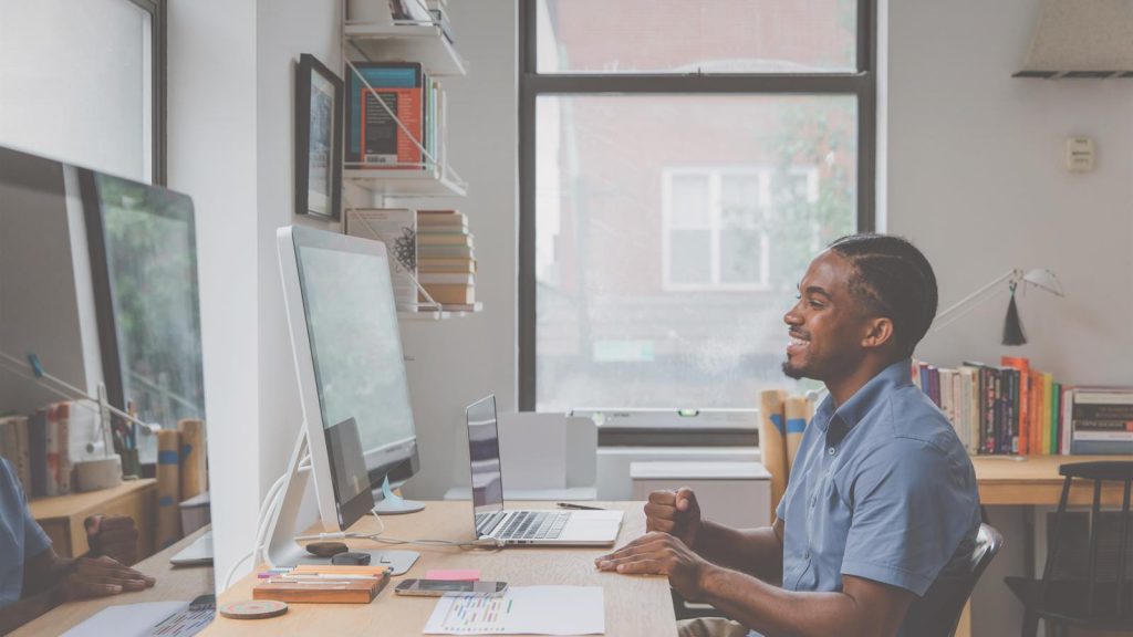 Person listening to an audiobook at a desk, showing how Audible gift vouchers fit into everyday reading routines